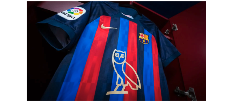 a soccer jersey with light blue, red, and dark blue stripes, with a line drawing of an owl in the center