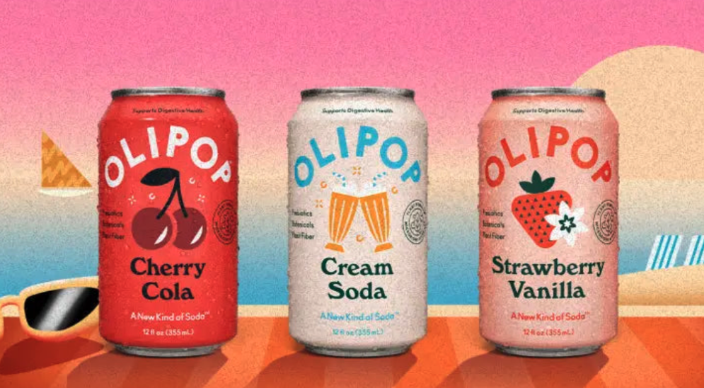 Three cans of soda including cherry, cream soda, and strawberry vanilla flavors sit on a table with a sunset in cartoon form behind them. 
