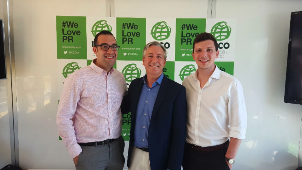 Ogilvy PR’s Michael DiSalvo, CEO Stuart Smith and Ben King stand in front of a wall filled with industry posters. 