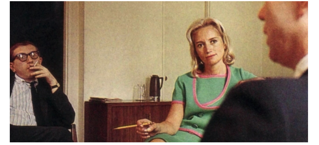 Photo of Mary Wells Lawrence sitting in a chair with pencil poised on her lap. 