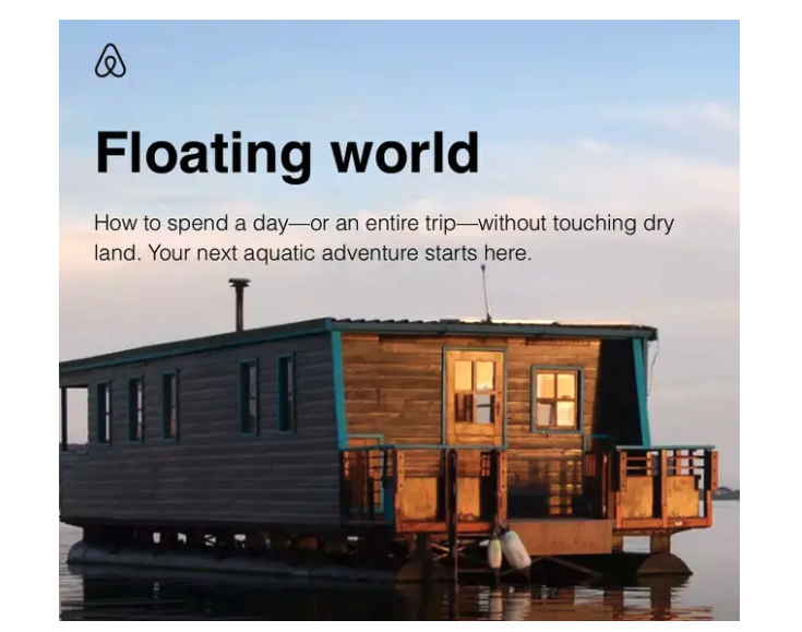 a houseboat with wooden siding, floating on a body of water
